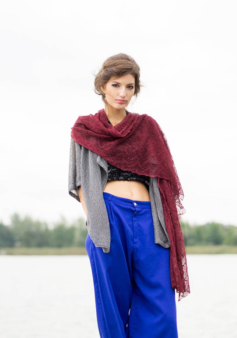 Peut inclure: Une femme portant un cardigan en tricot gris sur un haut court noir, une &eacute;charpe en dentelle bordeaux et un pantalon bleu &agrave; jambes larges.