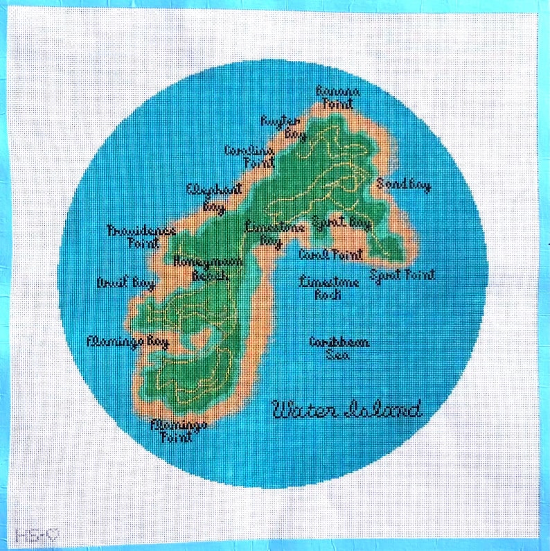 Op de afbeelding: Een handgestikte kaart van Water Island, met een groen eiland omringd door een blauwe oceaan. De kaart bevat plaatsnamen zoals Banana Point, Honeymoon Beach en Flamingo Bay. De tekst "Water Island" staat onderaan.