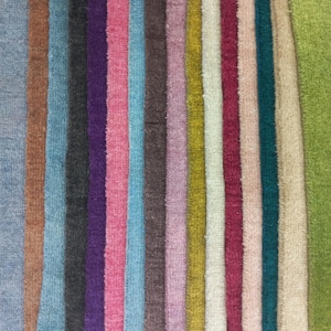 May include: A collection of vertical fabric strips arranged side by side, featuring a diverse palette of colours including light blue, brown, teal, dark purple, pink, sky blue, dark brown, mauve, mustard yellow, cream, maroon, beige, and lime green.