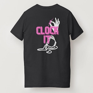 May include: Black t-shirt with a graphic design on the back. The design features the words "CLOCK IT" in pink, a white hand holding a needle, and a spilled coffee cup. The shirt is a basic crew neck.