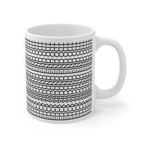 May include: White ceramic coffee mug with a black geometric pattern. The design features rows of various shapes, including circles, triangles, and lines. The mug has a curved handle and is suitable for hot or cold beverages.
