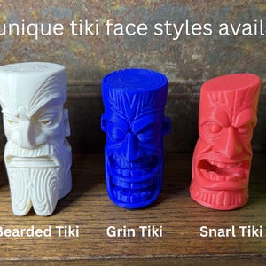 May include: Five colorful tiki face sculptures in orange, white, blue, red, and green. Each tiki has a unique expression and design, with names like Wide-Eye, Bearded, Grin, Snarl, and Skull. The text "Five unique tiki face styles available" is at the top.