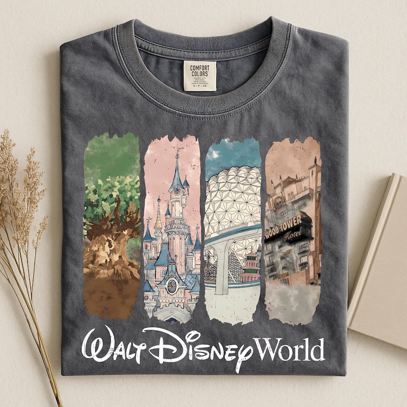 May include: Dark gray t-shirt featuring a colorful graphic of Walt Disney World landmarks. The design includes images of a castle, a tree, a geodesic sphere, and a hotel. The words "Walt Disney World" are printed in white script across the bottom.