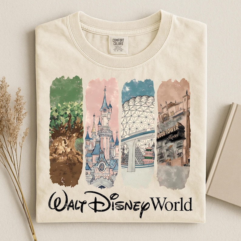 May include: Cream-colored t-shirt featuring a colorful illustration of Walt Disney World landmarks. The design includes images of a tree, a castle, a geodesic sphere, and a hotel, with "Walt Disney World" written below.