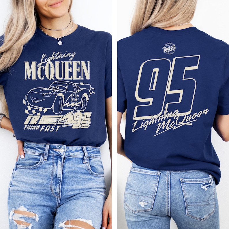 Pode incluir: Camiseta azul marinho com gr&aacute;ficos de Lightning McQueen. A frente mostra o carro com o texto "Lightning McQueen" e "Think Fast". A parte de tr&aacute;s mostra um grande "95" e o texto "Lightning McQueen".