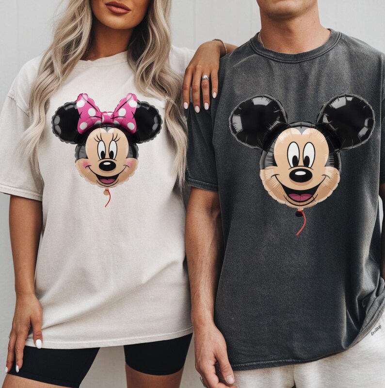 Peut inclure: Un t-shirt cr&egrave;me avec un motif de ballon Minnie Mouse portant un n&oelig;ud rose &agrave; pois et un t-shirt gris anthracite avec un motif de ballon Mickey Mouse. Les deux t-shirts pr&eacute;sentent des manches courtes et une encolure ronde classique.