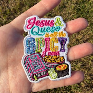 May include: An embroidered patch featuring the text Jesus & Queso is all the SPICY I need. The design includes a pink book labelled The Holy Bible, a bowl of yellow tortilla chips, and a small black pot of orange queso with two lime slices.