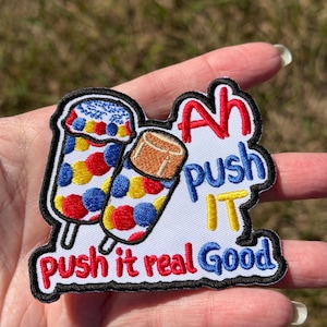 May include: An embroidered patch featuring two colorful ice cream popsicles with red, blue, and yellow circular patterns. The text reads Ah push IT and push it real Good in red, blue, and yellow thread against a white background with black borders.