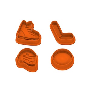 Puede incluir: Cuatro cortadores de galletas naranjas con forma de equipamiento de hockey. Las formas incluyen un patín de hockey, un palo de hockey, un casco de hockey y un disco redondo.