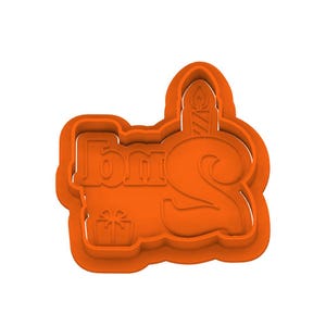 Puede incluir: Cortador de galletas de plástico naranja con la forma de la palabra "Tom's" con el número "2" y una vela. También se incluye una pequeña caja de regalo en el diseño. El cortador está diseñado para hacer galletas.