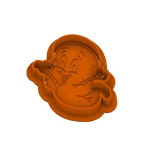 May include: An orange cookie cutter featuring the embossed outline of a cartoon ghost character with large eyes, raised eyebrows, and a wide smiling mouth, designed with a thick outer border and internal raised lines for detailed impressions.