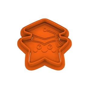 May include: Orange plastic cookie cutter in the shape of a smiling star wearing a graduation cap. The cutter has a detailed design with a tassel on the cap and a friendly face.
