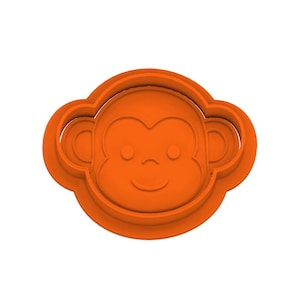 May include: Orange plastic monkey face cookie cutter. The cutter features a smiling monkey face with round eyes and ears. The cutter is designed for making cookies or other treats in the shape of a monkey.