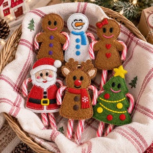 May include: Six felt Christmas ornaments shaped like a gingerbread person, snowman, gingerbread person with a bow, Santa Claus, reindeer, and a Christmas tree. Each ornament is attached to a red and white striped candy cane handle.