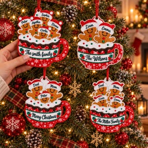 May include: Four embroidered Christmas ornaments shaped like red mugs filled with gingerbread people wearing Santa hats. Each mug features personalized text such as The Smith Family, The Wilsons, Merry Christmas, or The Miller Family.