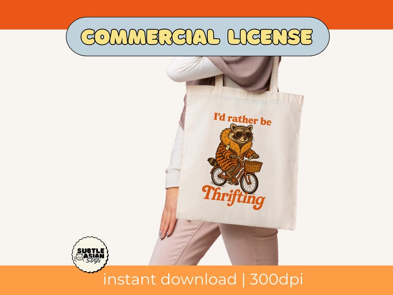 May include: Cream-colored tote bag featuring a raccoon riding a bicycle with a basket. The raccoon wears sunglasses and a fur-trimmed coat. Text on the bag reads "I'd rather be Thrifting" in orange. The image includes the words "COMMERCIAL LICENSE".