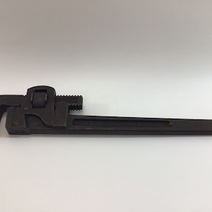 May include: A black pipe wrench with a silver adjustment knob. The wrench is made of metal and has a long handle.