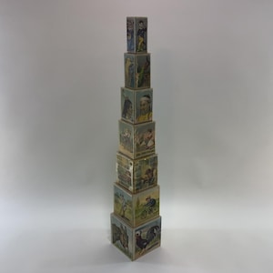 May include: A stack of vintage wooden nesting blocks. Each block features colorful illustrations of people, animals, and scenes. The blocks are arranged in a tower, showcasing the various images on each side. The overall aesthetic is nostalgic and playful.