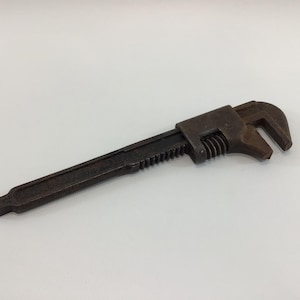 May include: A rusty adjustable wrench with a black handle.