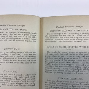 May include: A vintage cookbook with a yellowed, cream-colored cover and black text. The title of the book is "Practical Household Receipts." The book contains recipes for Cream of Tomato Soup, Velvet Soup, Clam Soup, Country Sausage with Apples, and Squab or Quail Stuffed with Force Meat.