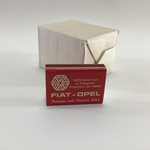 May include: Red matchbook with white text advertising Fiat-Opel Antique and Classic Cars. The address is 2225 Dixie Hwy. at Telegraph, Pontiac, MI 48055.