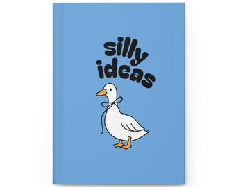 May include: A light blue journal with the words "silly ideas" in black script. A white cartoon duck with a black bow is below the text. The journal is rectangular and has a clean, minimalist design.