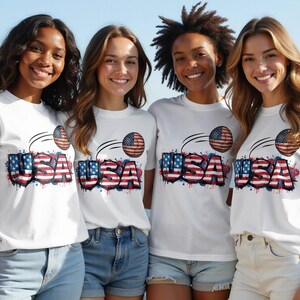 Four women in USA graphic t-shirts stand together, smiling.