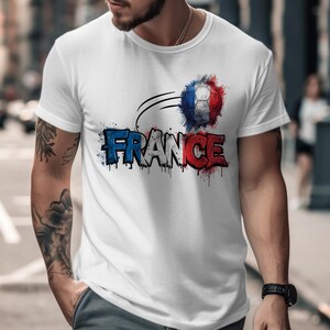White t-shirt with "FRANCE" text in red, white, and blue watercolor, featuring a soccer ball.