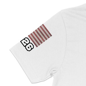 White t-shirt with "26" and American flag design on sleeve.