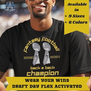 May include: Black t-shirt with a gold and silver design. The shirt features the text "Fantasy Football" and "Back 2 Back Champion" with two trophy illustrations. Additional text indicates the shirt is available in 9 sizes and 6 colors.