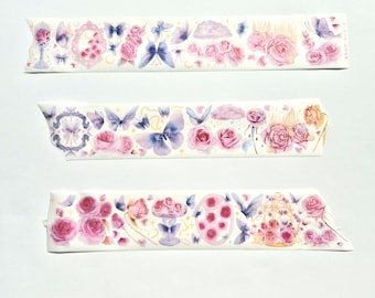 May include: Three decorative washi tape strips with a floral and butterfly design. The tape features pink roses, purple butterflies, and other whimsical elements. The tape is white with a watercolor style.