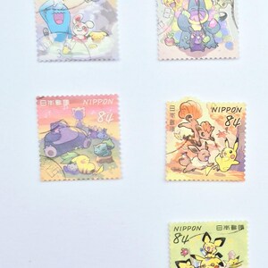 May include: Five colorful Japanese postage stamps featuring cartoon characters. Each stamp has the word "NIPPON" and the number "84" printed on it. The stamps are on a white background.