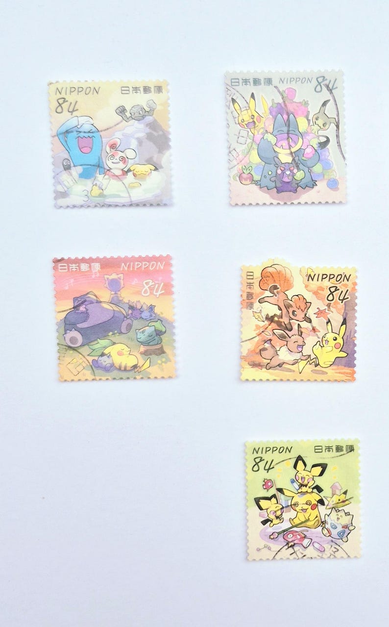May include: Five colorful Japanese postage stamps featuring cartoon characters. Each stamp has the word "NIPPON" and the number "84" printed on it. The stamps are on a white background.