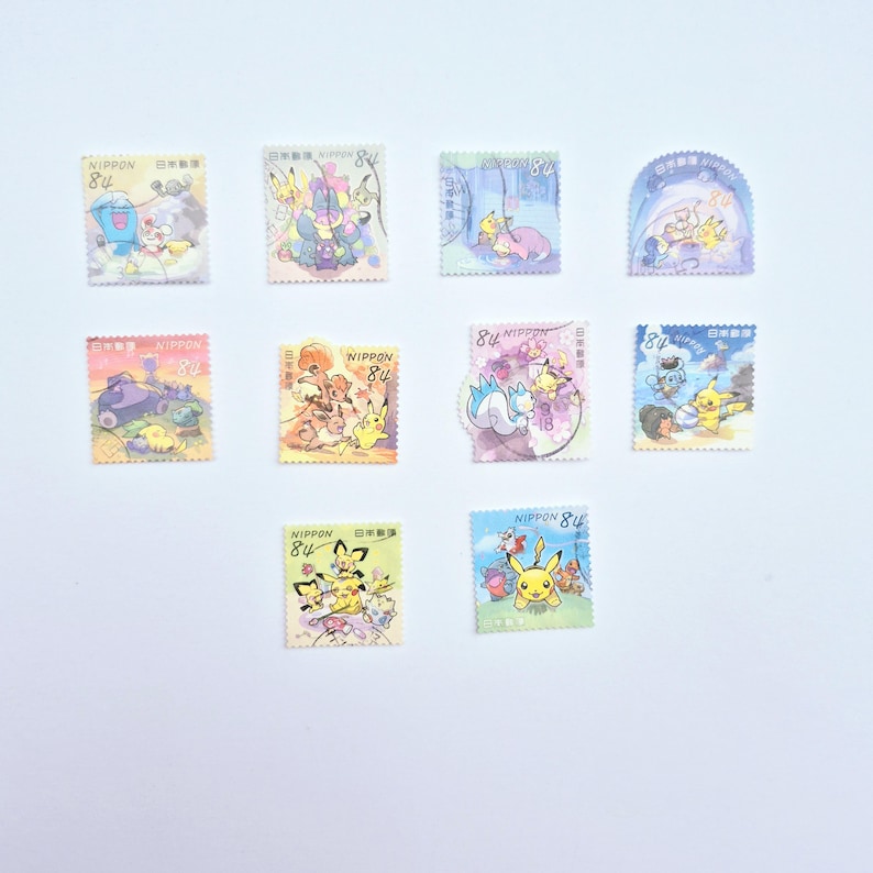 May include: A collection of colorful Japanese postage stamps featuring various Pok&eacute;mon characters. Each stamp has a unique design with vibrant illustrations and the text "NIPPON" and "84" printed on them. The stamps are arranged on a white background.