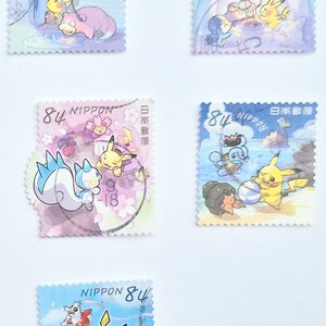 May include: A collection of Japanese postage stamps featuring colorful illustrations of various Pok&eacute;mon characters. Each stamp has the text "NIPPON" and the number "84". The stamps are in various shapes and sizes, with different Pok&eacute;mon depicted.