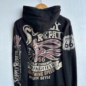 May include: Black hoodie with a Route 66 graphic. The back features a skull with a Native American headdress, the number 66, and the words "Springfield" and "Lightning Speed". The left sleeve says "Supply Repair".
