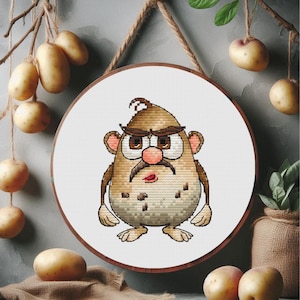 May include: A cross-stitch embroidery of a cartoon potato character with a brown mustache, eyebrows, and hair. The character has a grumpy expression and is set in a wooden hoop. Potatoes hang in the background.