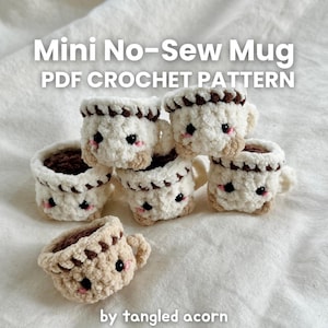 May include: A collection of six mini crochet mugs, each with a fluffy white body, brown trim, and a dark brown interior. The mugs have small handles and cute black eyes and pink cheeks. Text on the image reads "Mini No-Sew Mug PDF Crochet Pattern" and "by tangled acorn."