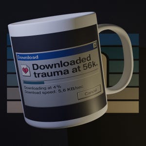 May include: White ceramic mug with a black and blue design. The mug features a mock computer download window with the text "Downloaded trauma at 56k." A broken heart icon is visible. The mug has a curved handle.