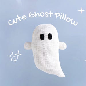 May include: A white crocheted ghost pillow with black eyes and small arms. The text "cute ghost pillow" is written above the ghost. The background is light blue with white star and sparkle designs.