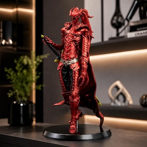 May include: A standing figurine of a warrior clad in metallic red segmented armor with a high collar, a flowing cape, and a silver belt. The figure holds a black sword at its side and features a pointed helmet with long, flowing red hair elements.