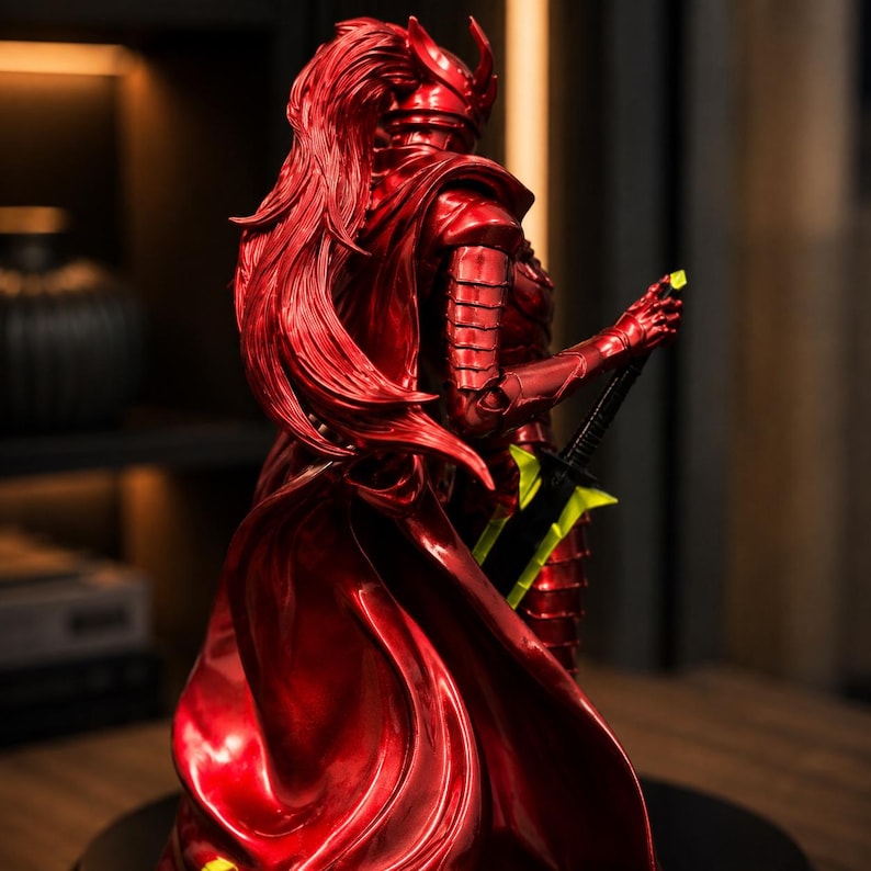 May include: A metallic red figurine of a warrior wearing segmented armor and a flowing cape. The figure has long, sculpted red hair and holds a black sword with a bright neon green blade and hilt accents, viewed from a rear three-quarter angle.