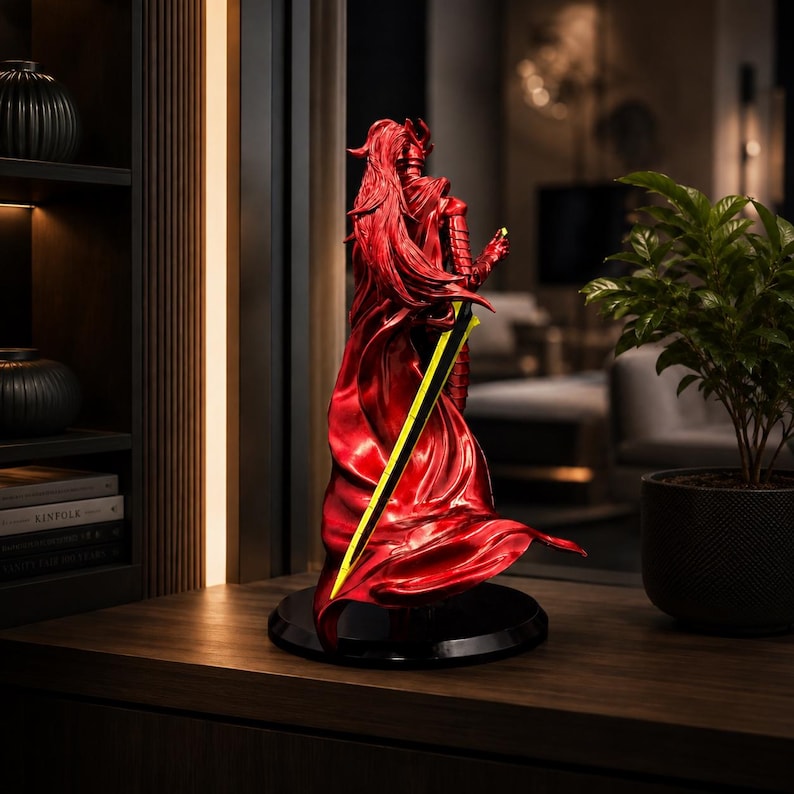 May include: A metallic red figurine of a warrior with long flowing hair and armor, standing on a circular black base. The figure holds a long, slender sword with a bright yellow blade that extends diagonally across the back of the sculpture.