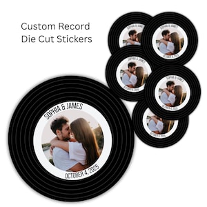 May include: Black die-cut stickers in the shape of vinyl records. Each sticker features a photo of a couple, the names "Sophia & James", and the date "October 4, 2025". The text "Custom Record Die Cut Stickers" is also visible.