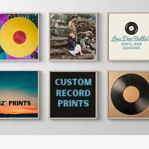 May include: Collection of framed prints featuring vinyl records and album art. One print displays a yellow record with a red center. Other prints include text: "Every Thing In Between", "Lou Dee Belle's Vinyl and Designs", "12" Prints", and "Custom Record Prints".