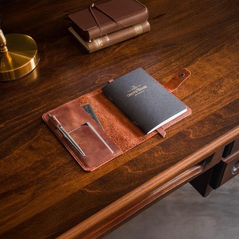 Elevate your journaling with our Custom Leather Notebook Cover. This handmade leather cover fits A5 or A6 sizes and is perfect as a refillable leather journal or travel notebook cover. Add your name or initials for a personalized notebook cover that’s stylish and practical. Great as a gift or everyday essential. Order now and carry your thoughts in timeless leather elegance!