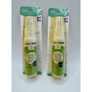 Può includere: Due flaconi di colla per tessuti Fabric Fuse. Ogni flacone trasparente ha un nebulizzatore e un'etichetta bianca e verde. L'etichetta riporta "Fabric Fuse" e "Quick Bond Fabric Adhesive". Ogni flacone contiene 61 ml.