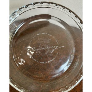 May include: A white ceramic mug with a black handle and the text "But First, Coffee" in a handwritten style. The mug is on a white surface.