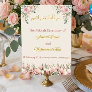 May include: A wedding table sign with floral decorations. The sign says "The Nikkah Ceremony of Jannat Kamal and Muhammad Faris, 14 February 2026 in the city of London, United Kingdom." It is held by a gold stand.