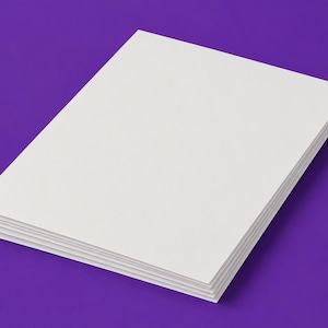 May include: A stack of rectangular white paper sheets with sharp corners, arranged in a neat pile. The paper is blank and opaque, featuring a smooth, matte surface texture. The stack is positioned at an angle, showcasing the layered edges of the sheets.